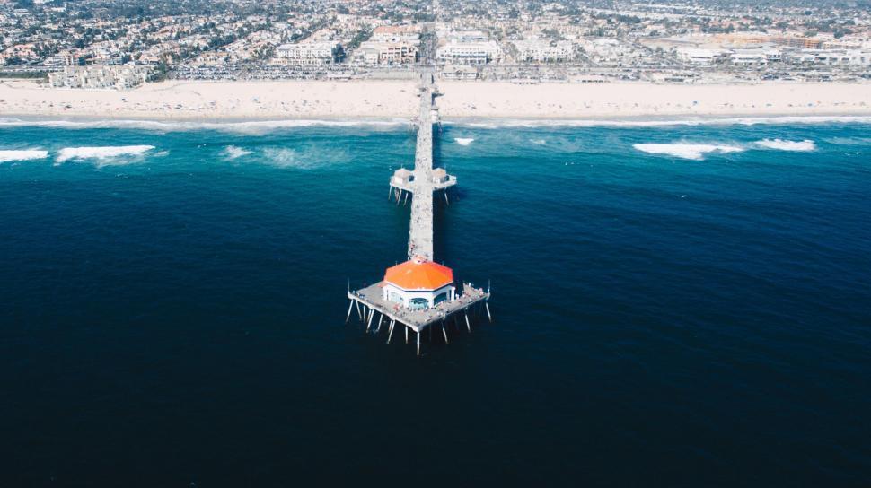 Free Image of Aerial view of pier extending into the blue ocean water. 
