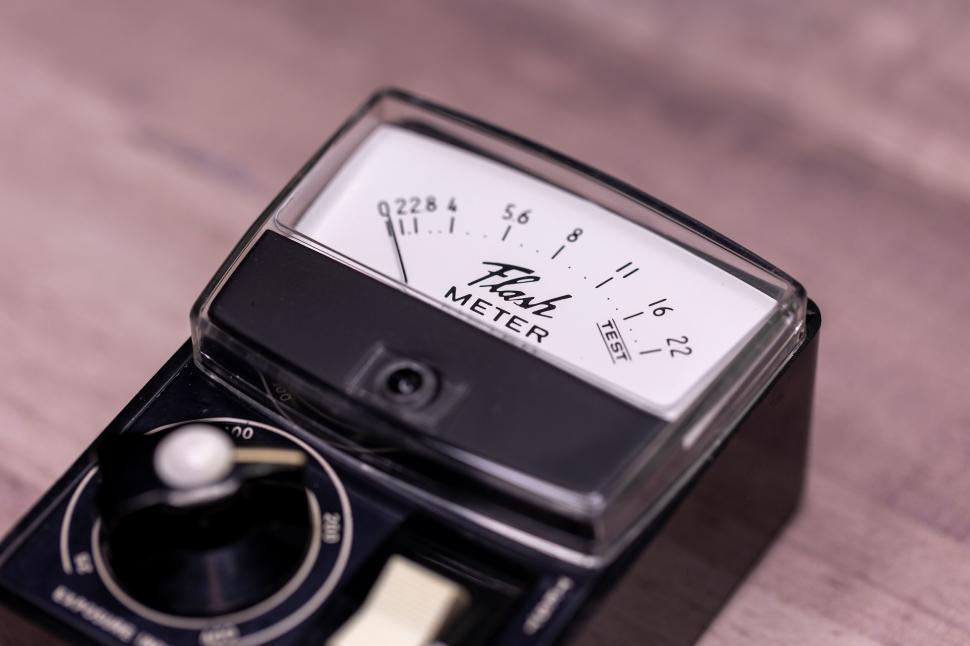 Free Image of Vintage flash meter with analog display on wooden surface. 