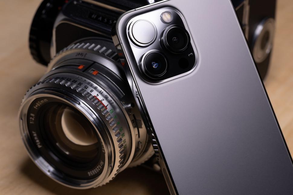 Free Image of Modern smartphone alongside classic camera lens details. 