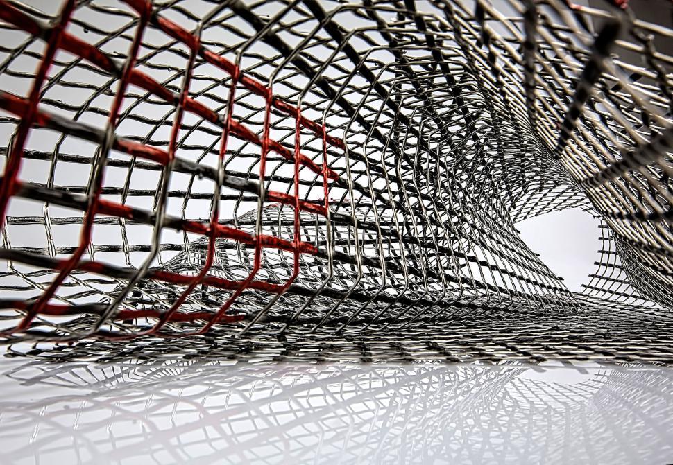 Free Image of Mesh-like tunnel structure with red and gray elements. 