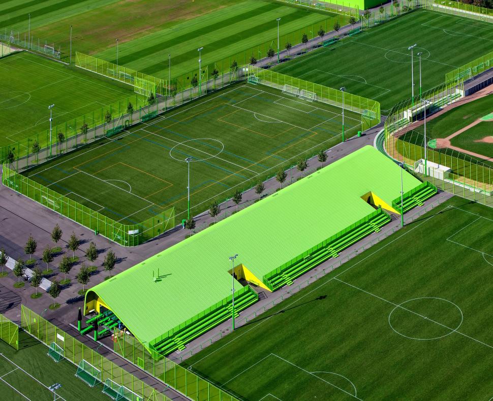 Free Image of Sports complex with multiple green soccer fields and stands 