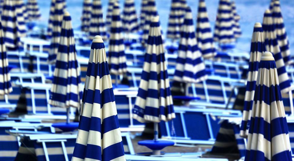Free Image of Sea of blue and white striped beach umbrellas 
