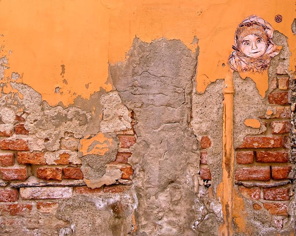 Free Image of Wall art with peeling paint and child portrait graffiti 