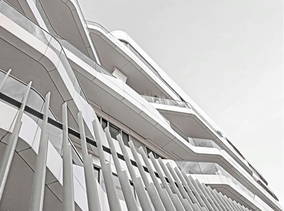 Free Image of Futuristic white building with reflective glass and curves. 