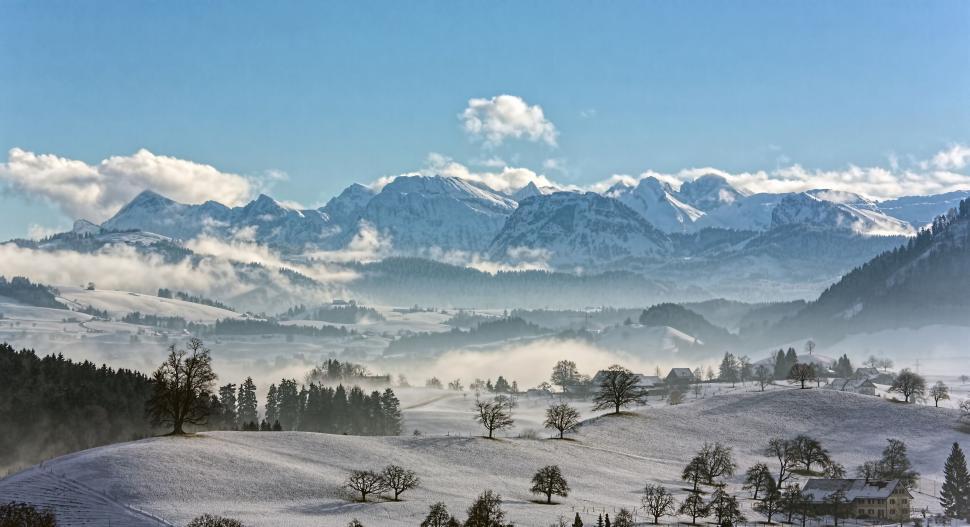 Free Image of Snow-covered landscape with mountains and clear blue sky. 