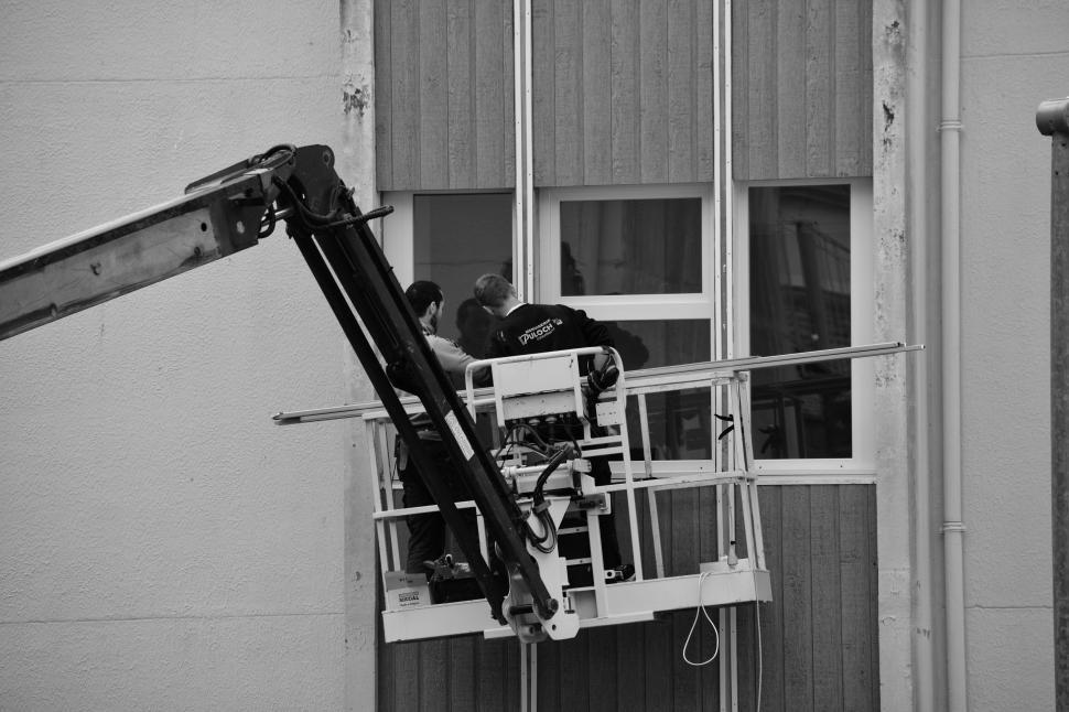 Free Image of Workers on a high rise platform installing a structure. 