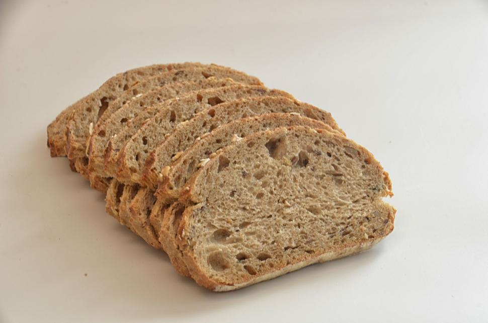 Free Image of Slices of whole-grain bread neatly arranged in a row. 