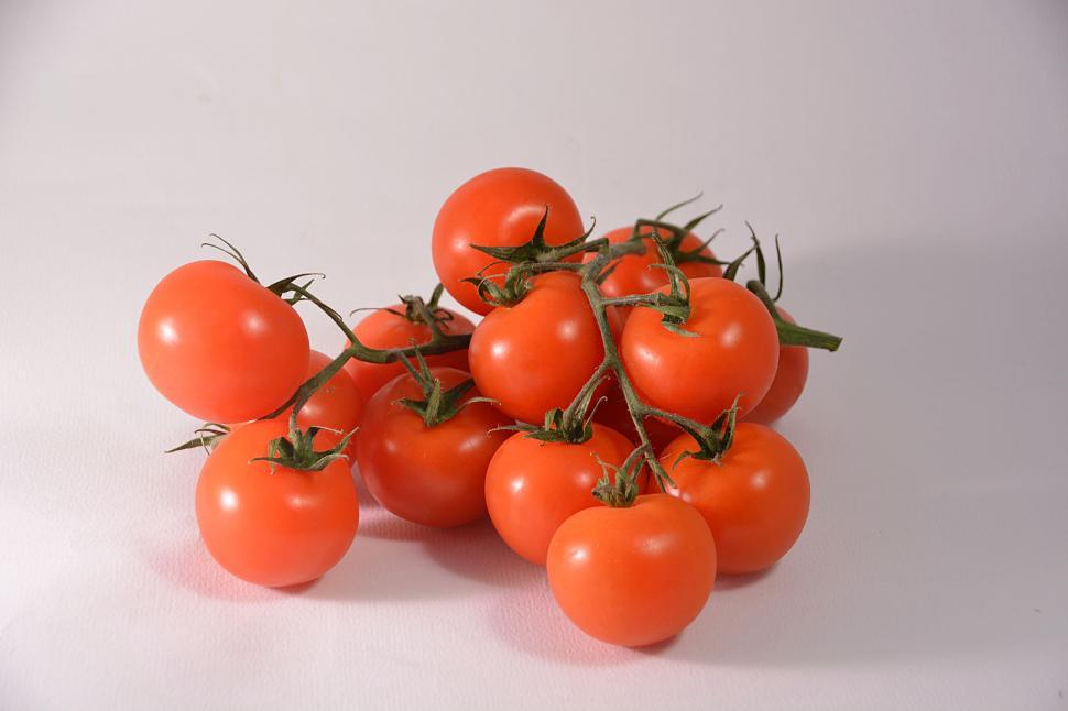 Free Image of A bunch of fresh red tomatoes on a light background. 