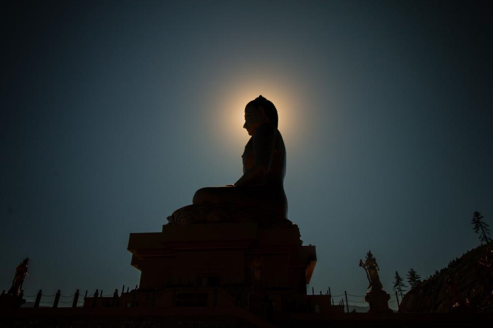 Free Image of Silhouette of a statue with a halo effect against sky 