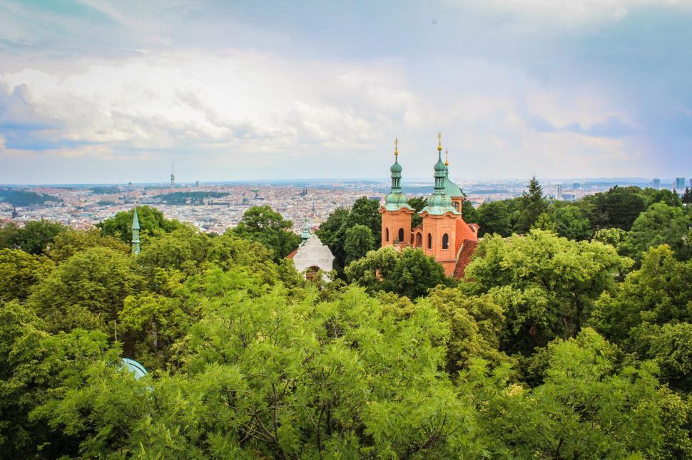 Free Image of Scenic view of church amidst lush greenery and cityscape 