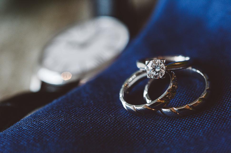 Free Image of Close-up of diamond engagement and wedding rings on fabric 
