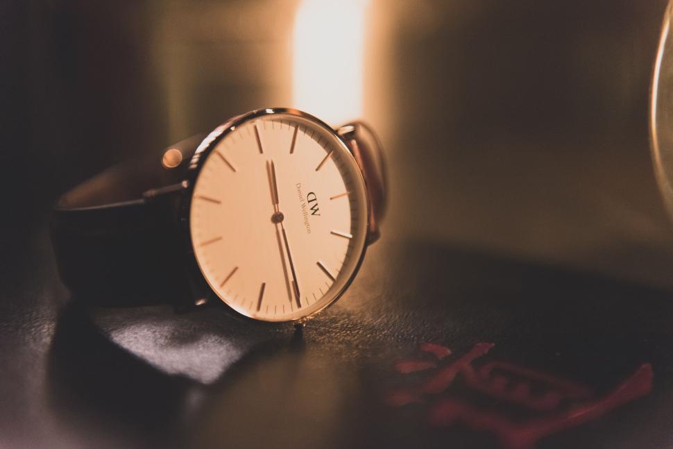 Free Image of Classic wristwatch resting on a surface with a soft glow. 