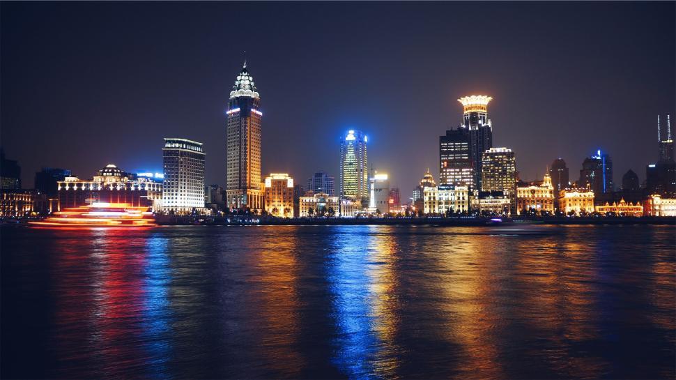 Free Image of Illuminated city skyline reflecting on calm water surface 