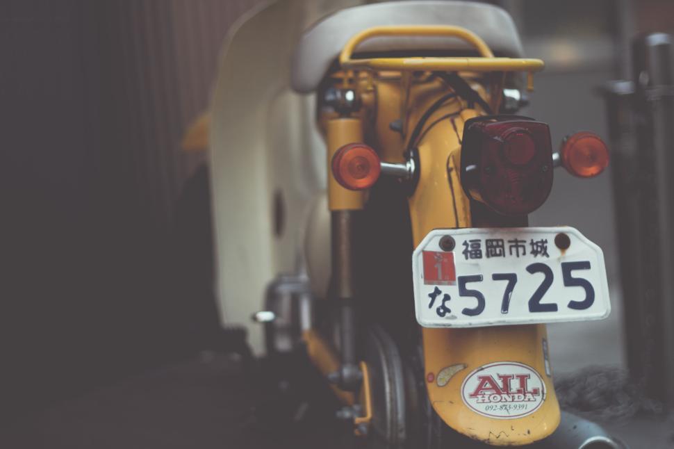 Free Image of Yellow Honda scooter parked with a number plate visible 