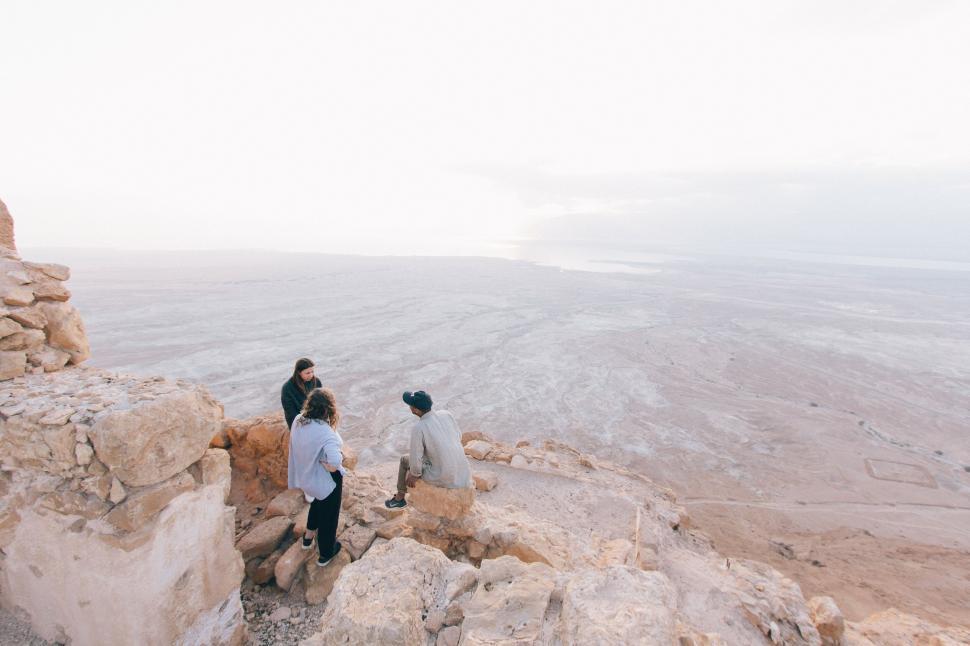 Free Image of People conversing on cliff overlooking vast desert. 