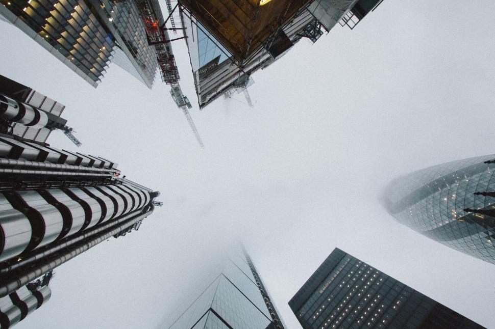 Free Image of Skyscrapers and cranes on a foggy day, towering skyline 