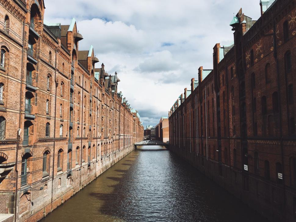 Free Image of Historical red brick buildings lining a narrow canal view. 