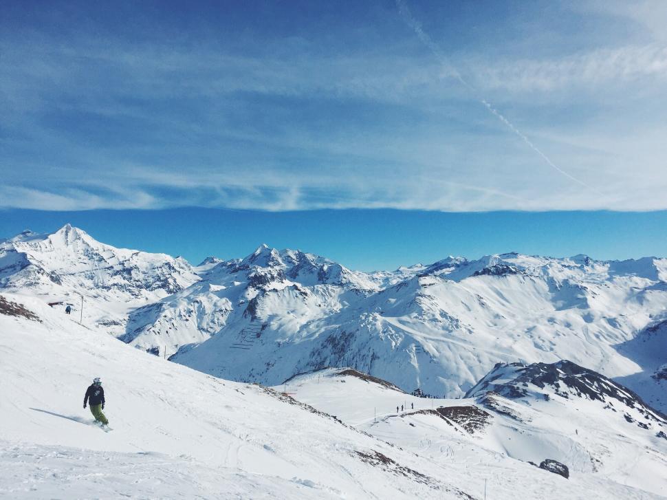 Free Image of Snow-covered mountains under a clear blue sky view 