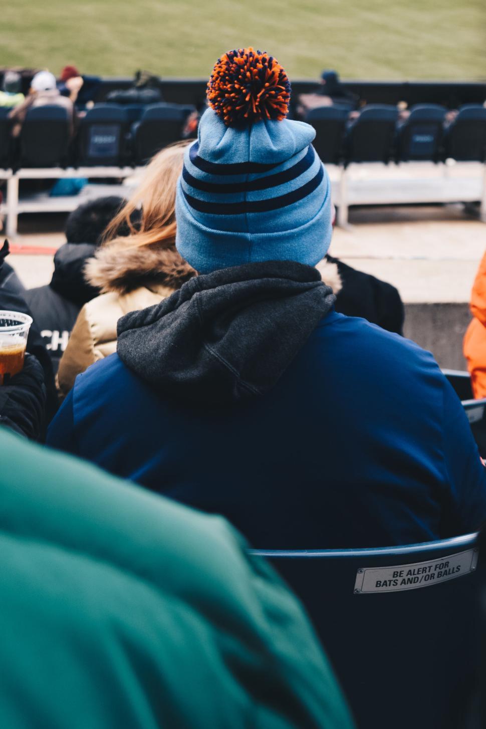 Free Image of Person wearing blue hat with pom pom, back view. 