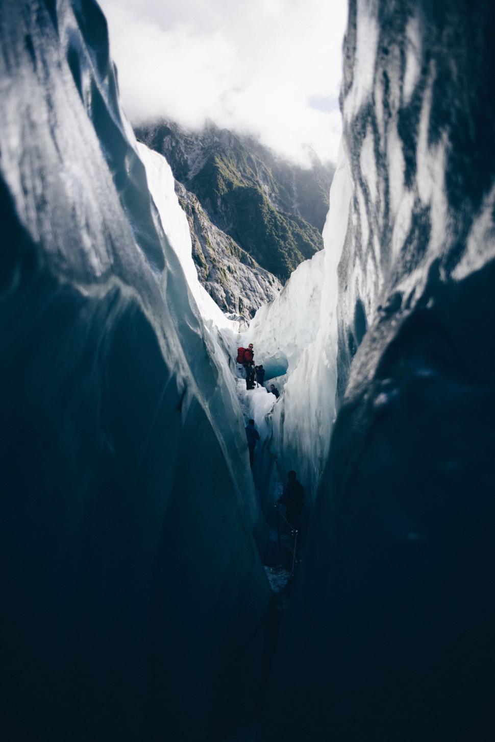 Free Image of Hikers in an ice canyon exploring the narrow pathway 