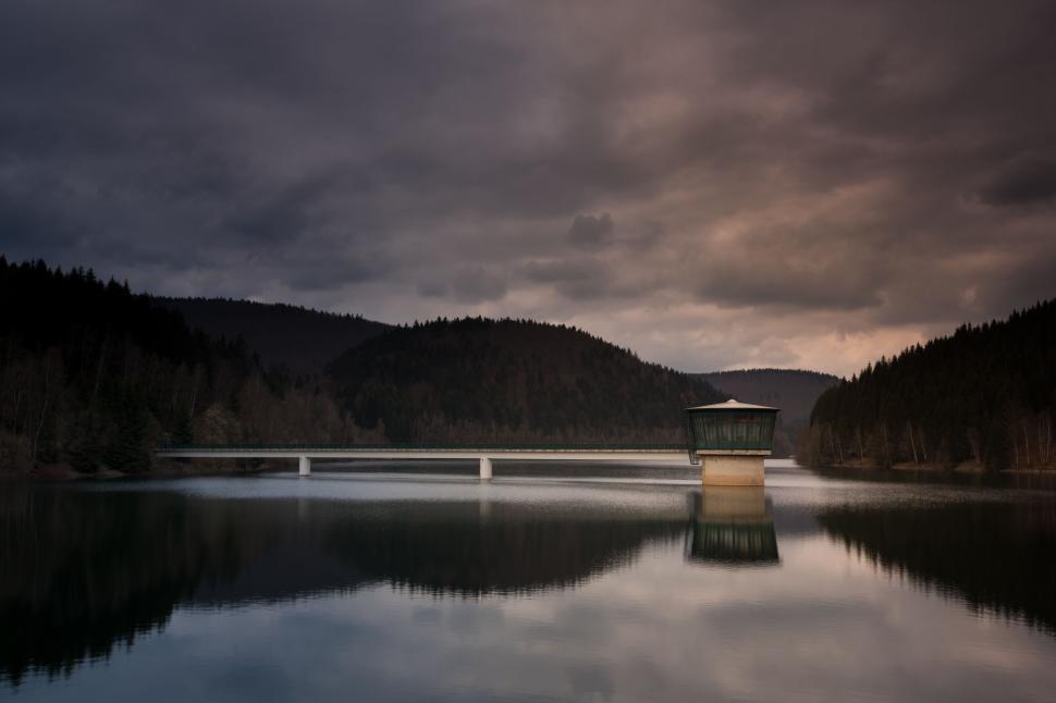 Free Image of A lone house by the lake, reflecting on the water s surface. 