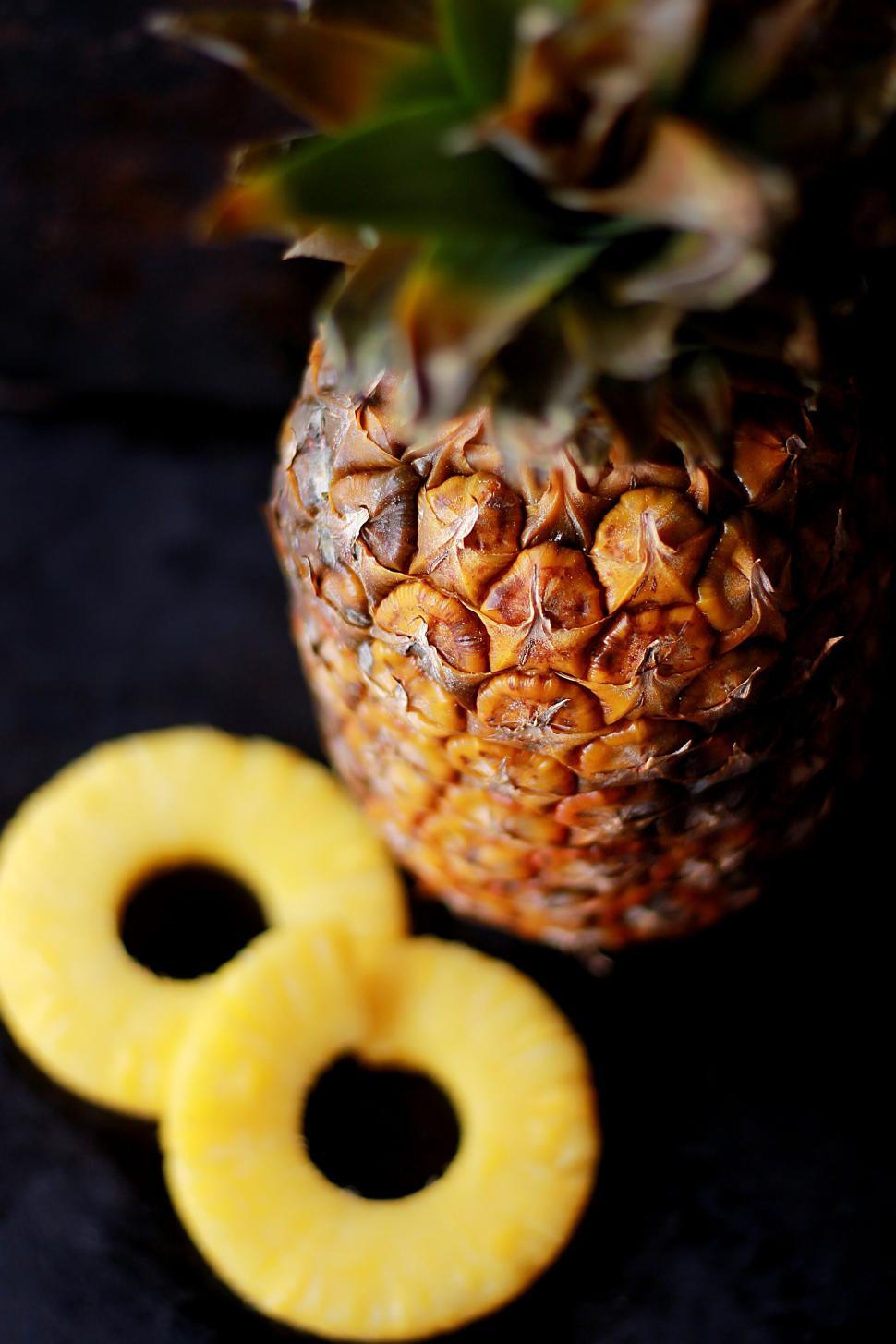 Free Image of Whole pineapple with rings on a dark background surface 