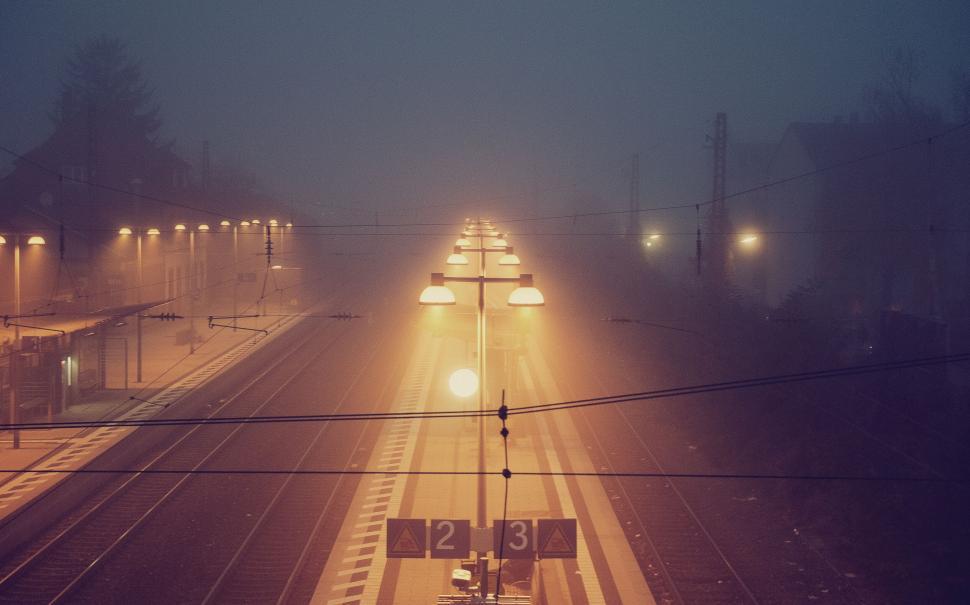 Free Image of Foggy train station illuminated by soft glowing lights. 