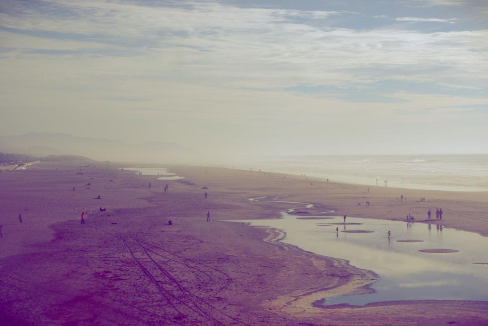 Free Image of Broad beach under cloudy sky with distant horizon view 