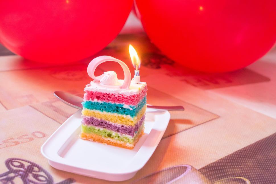 Free Image of Colorful birthday cake slice with single candle lit 