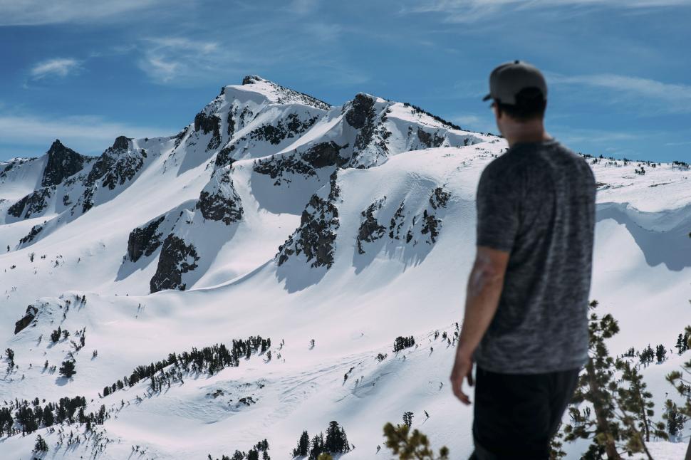 Free Image of Individual gazing at snowy mountain peaks in sunlight. 