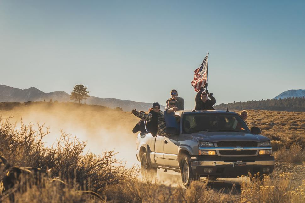 Free Image of Off-road adventure with friends waving a flag 