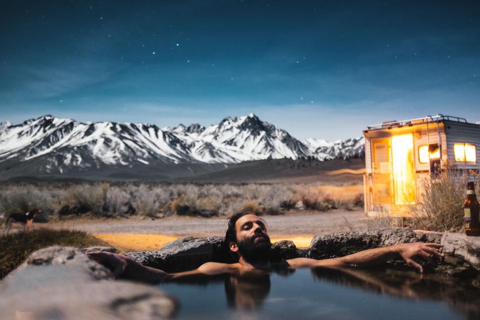 Free Image of Relaxing in a hot spring with a mountain backdrop 