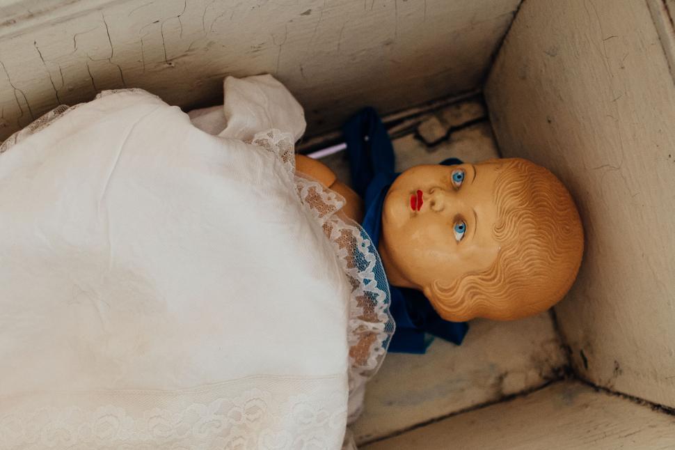 Free Image of Old-fashioned doll in a wooden box wrapped in fabric 