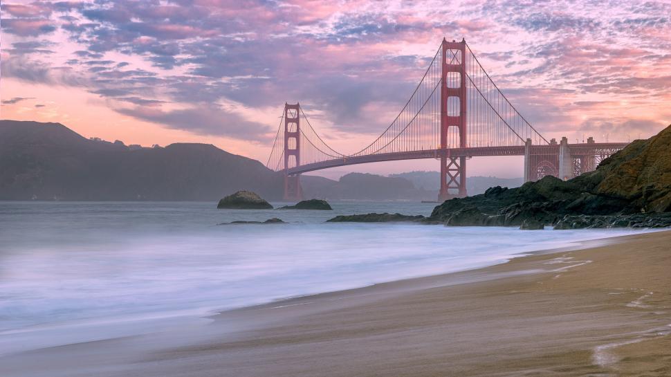 Free Image of Golden Gate Bridge at sunrise with scenic coastline. 