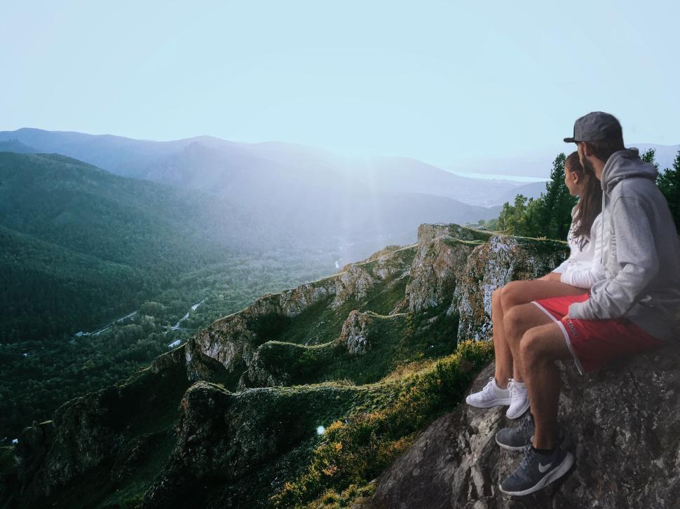 Free Image of Couple sitting on a mountain enjoying the scenic view 