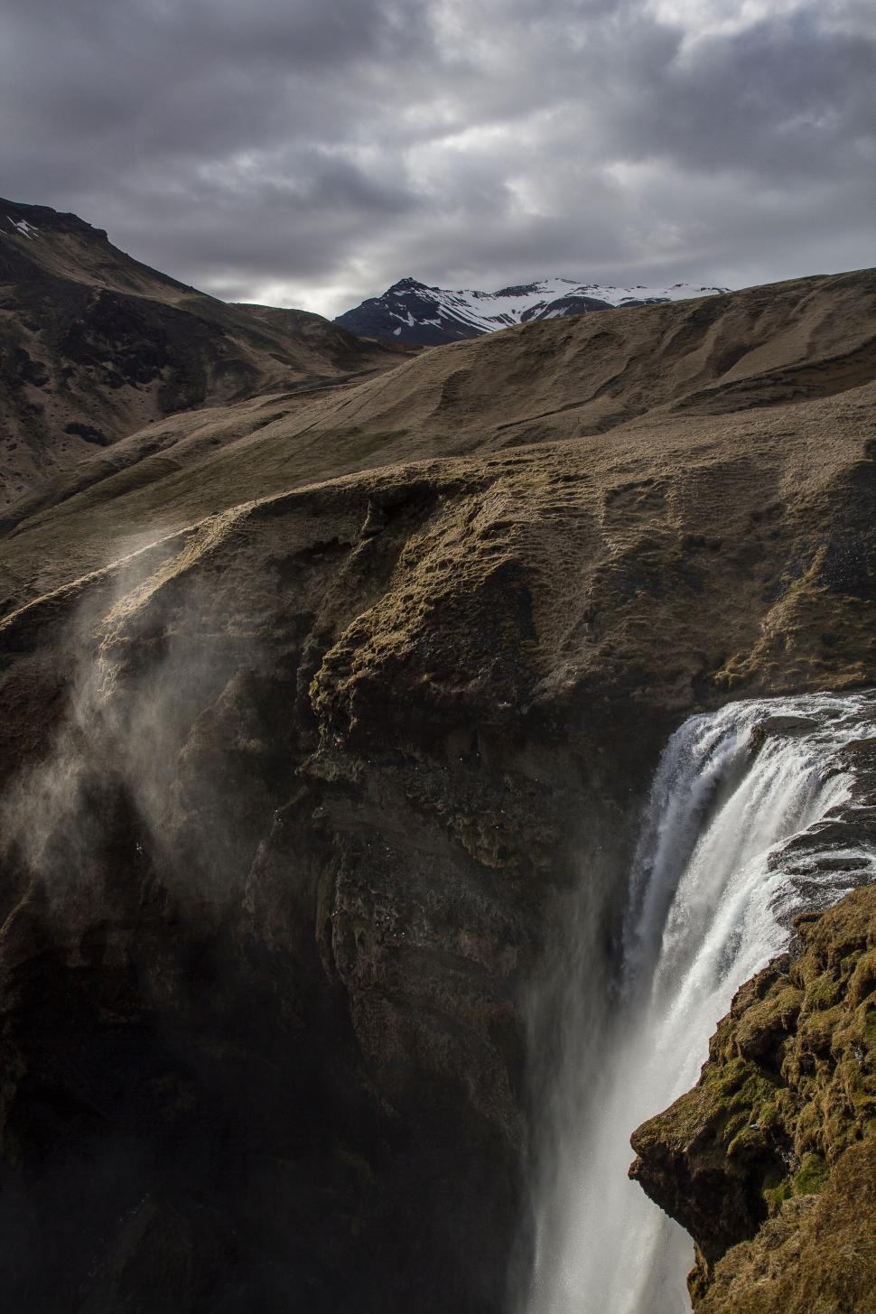 Free Image of Majestic waterfall cascading down a rocky cliffside 