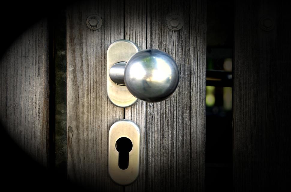 Free Image of Close-up photo of a metallic door knob on wooden door 