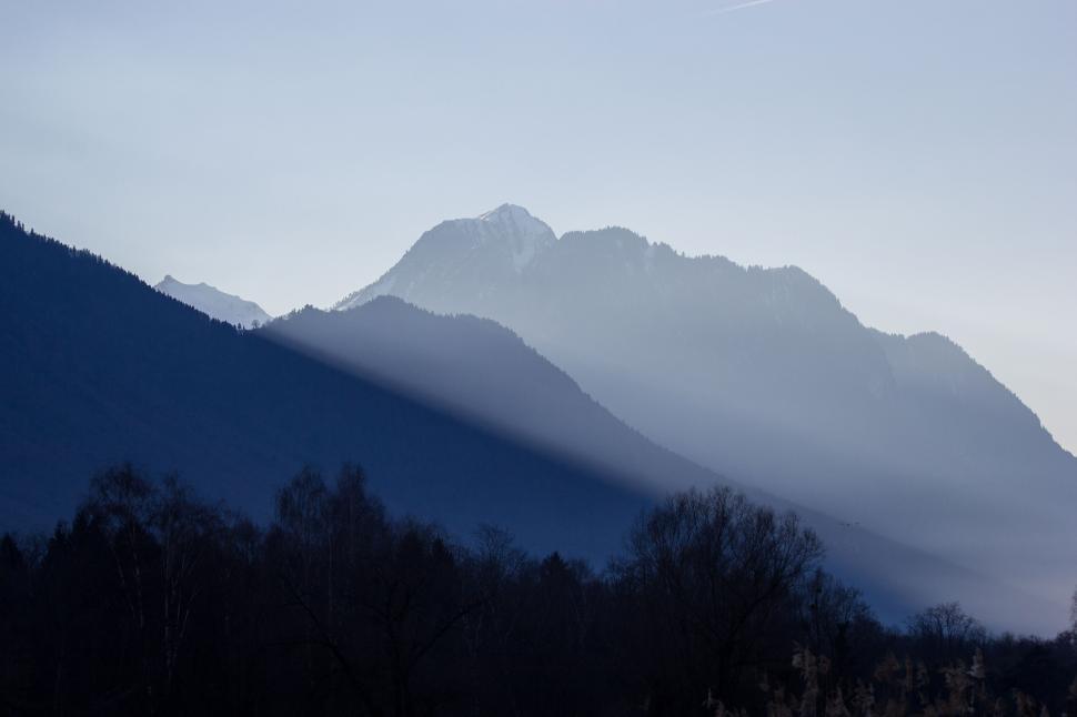 Free Image of Mountains with early morning fog and shadow across slopes 