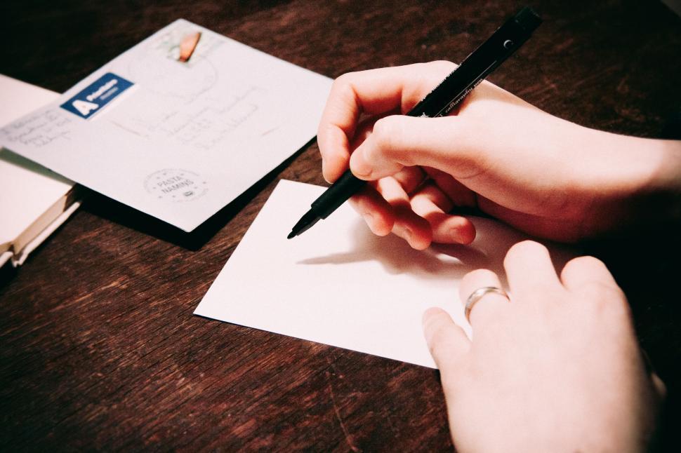 Free Image of Hand writing on a postcard with a fountain pen 