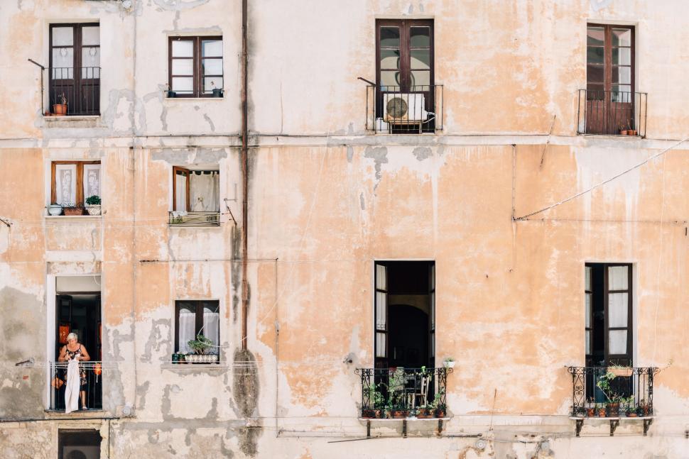 Free Image of Weathered building facade with people on balconies 