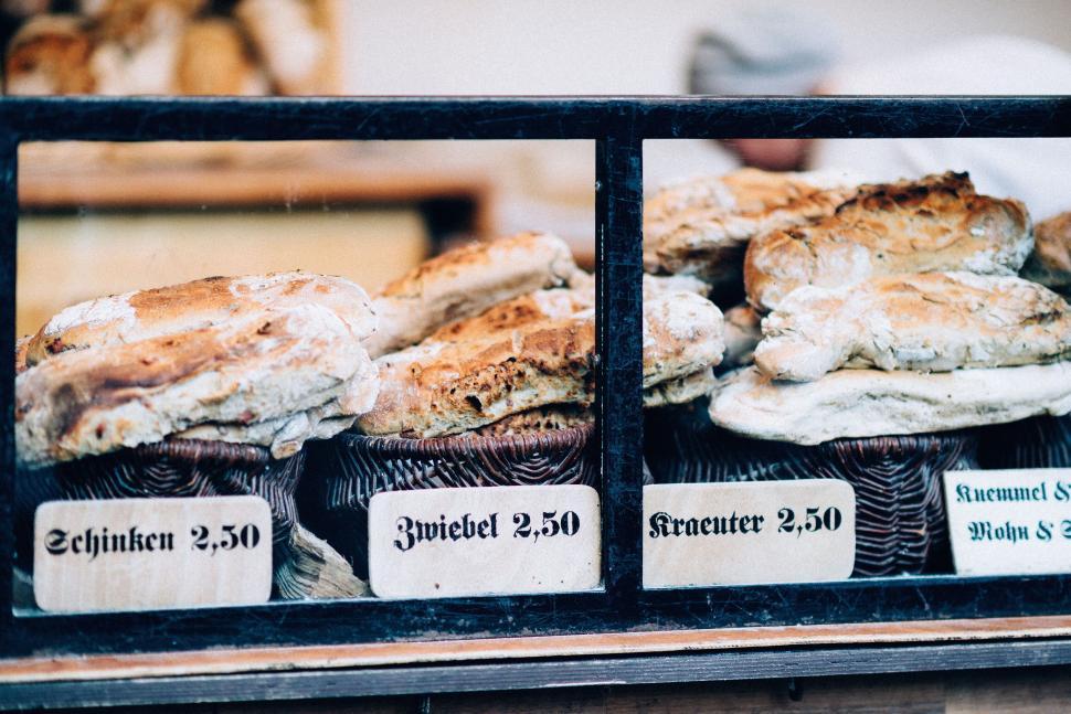 Free Image of Assorted artisan breads displayed with labels and prices. 