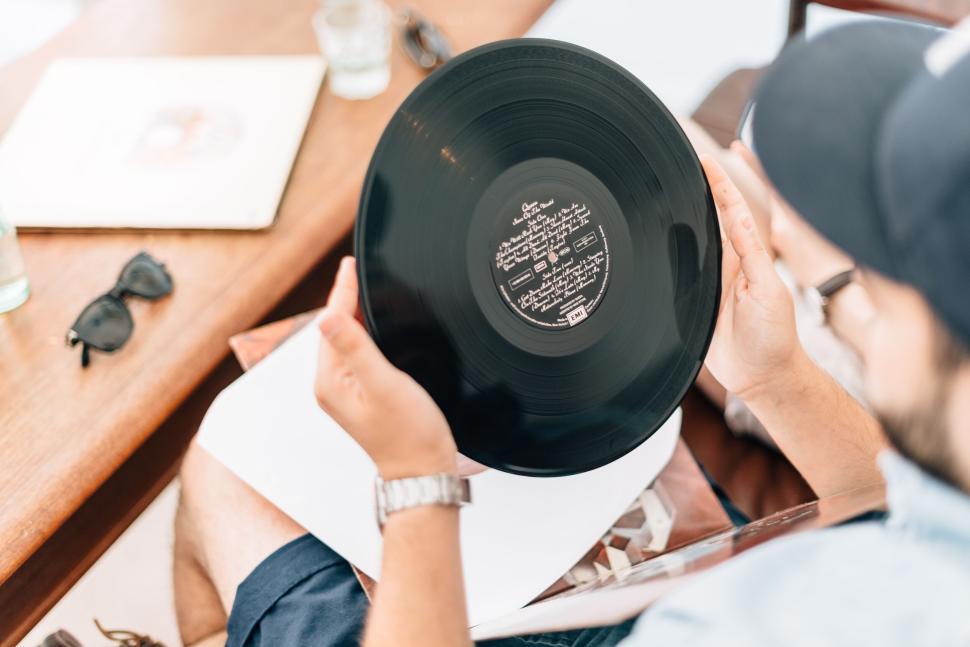 Free Image of Person holding vinyl record viewed from behind closely 
