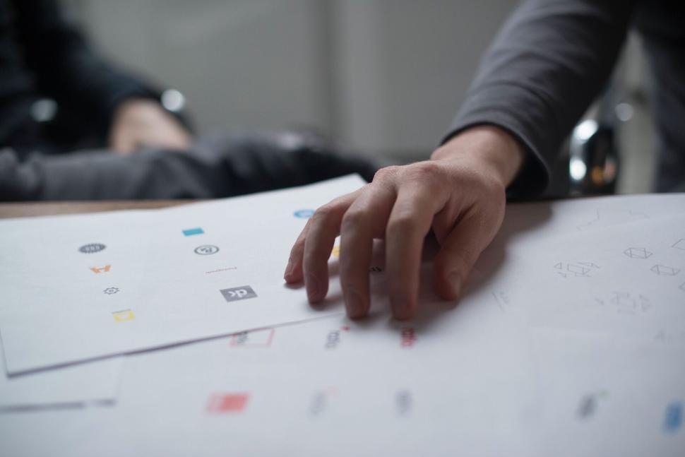 Free Image of Person examining design sketches and logo drafts on paper 