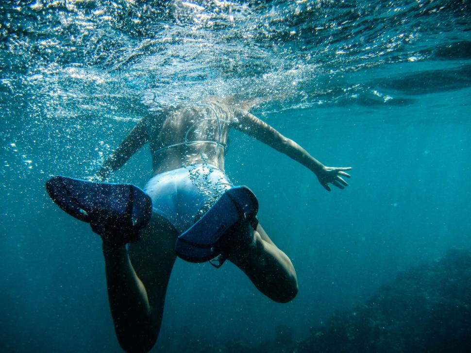 Free Image of Underwater swimmer with snorkel and flippers diving deep 