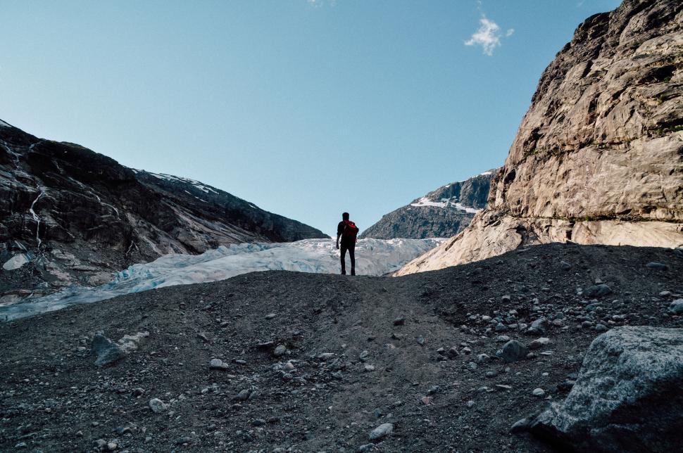 Free Image of Person standing in rocky terrain below a clear sky 