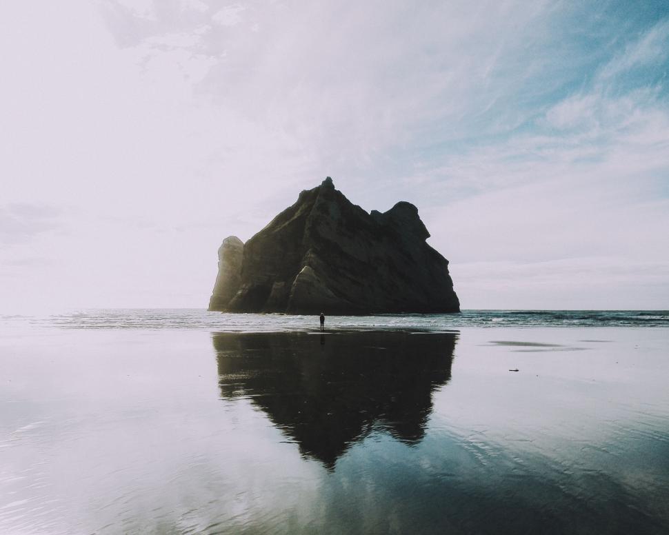Free Image of Rock formation reflecting in calm waters at dusk 