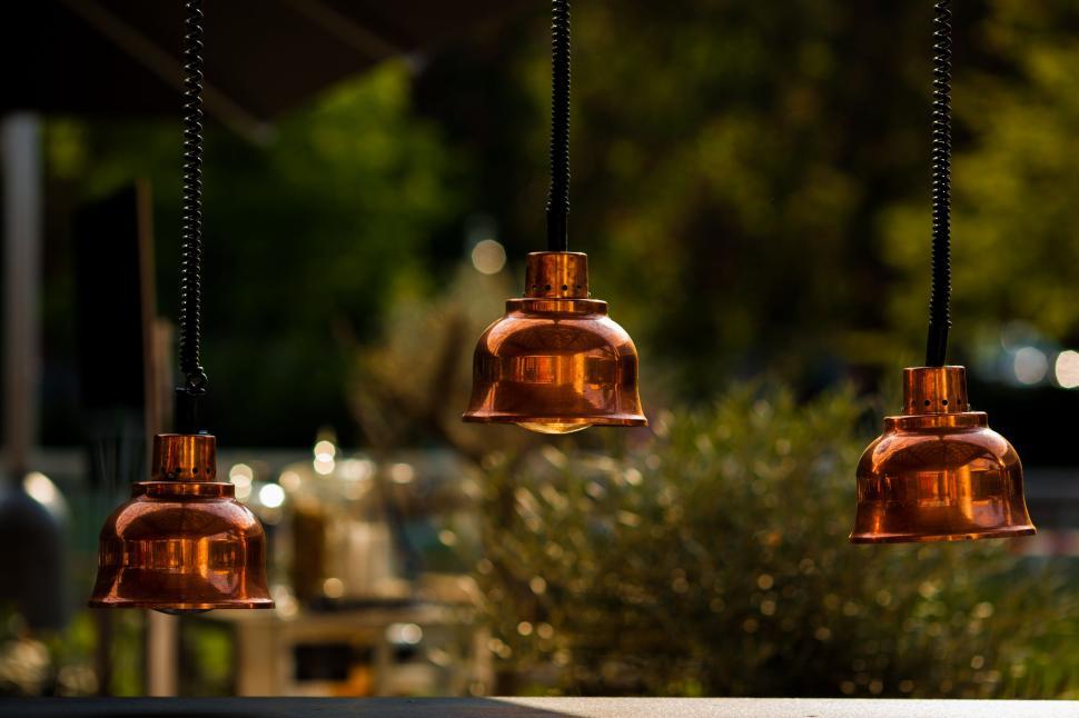 Free Image of Three hanging copper lamps with blurred background. 