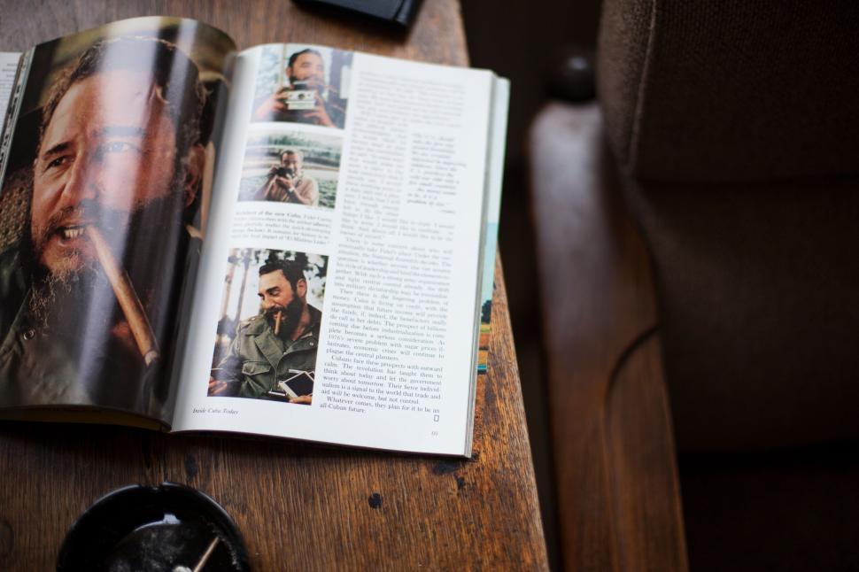 Free Image of Open magazine on wooden table with blurred images 