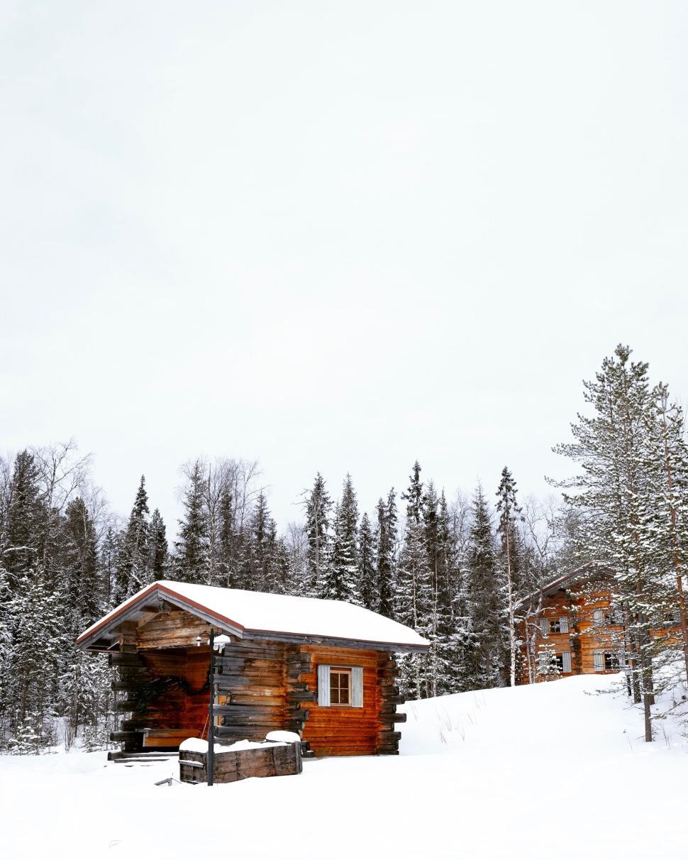 Free Image of Cozy wooden cabin in a snowy forest landscape 