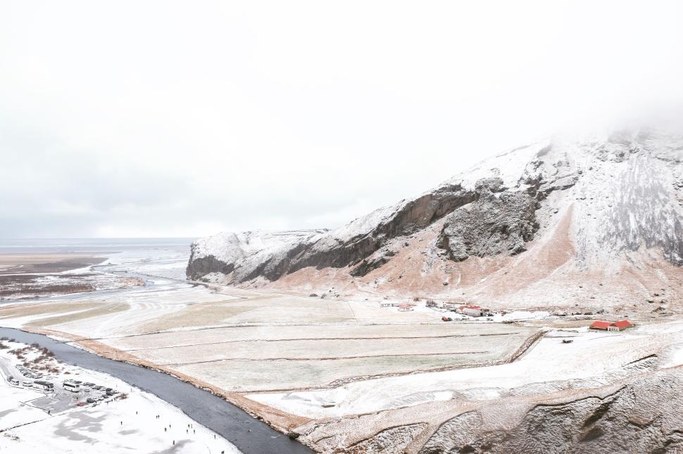 Free Image of Snow-covered fields near river and rocky mountains view 